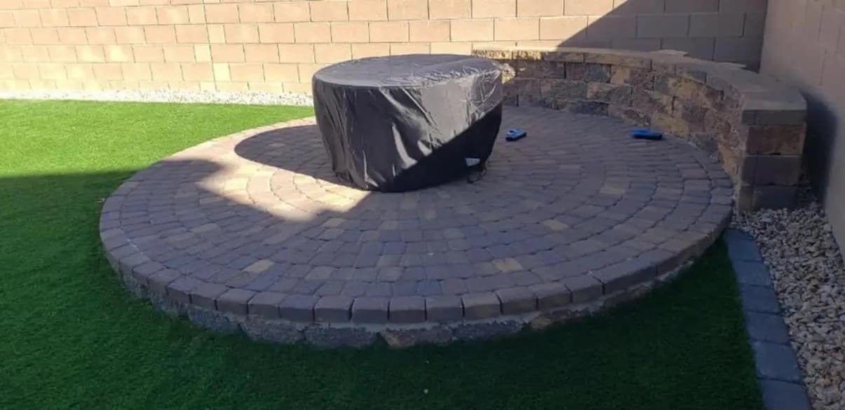 Circular paver patio with a fire feature and stacked-stone seat wall built in a Las Vegas backyard